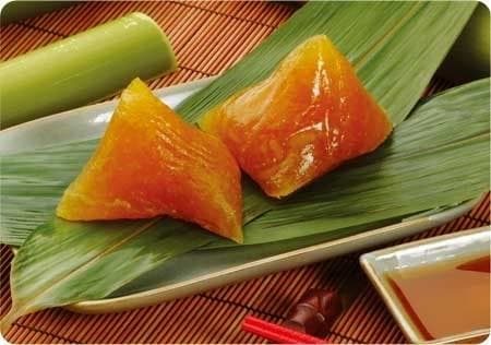 Bánh tro Đình Tổ màu hổ phách trong, đặt trên lá và ăn cùng mật