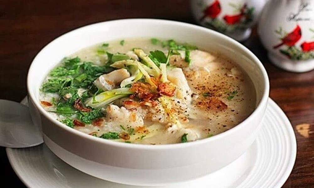Bát cháo cá Tích Nghi nóng với cá, hành và rau thơm