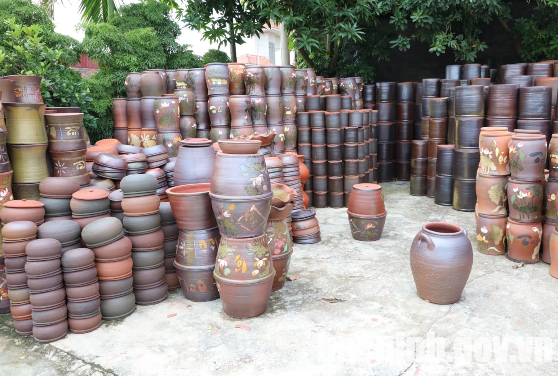 Các bình và chum gốm thành phẩm xếp trong sân một cơ sở ở Phù Lãng